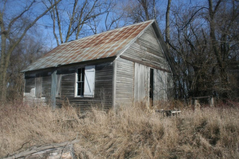 Photo of an unpainted schoolhouse