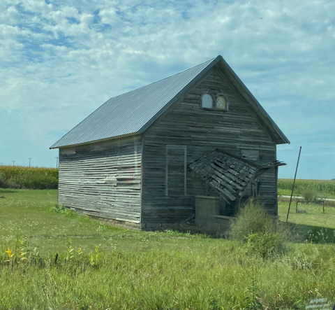 Photo of a rundown wooden schoolhouse