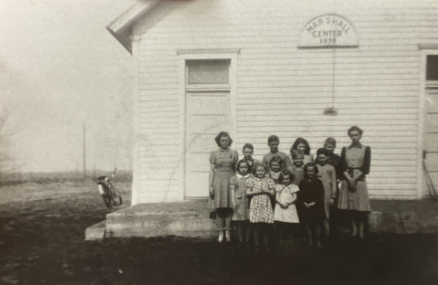 A class standing outside the school