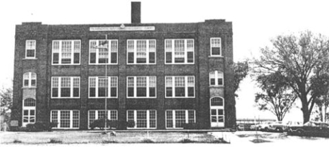 Photo of a three-story brick schoolhouse