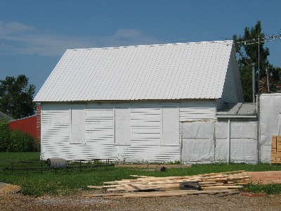 White schoolhouse with boarded up windows