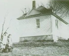 Children posing outside of the schoolhouse