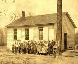 Yellowed class photo in front of the school