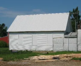 White schoolhouse with boarded up windows